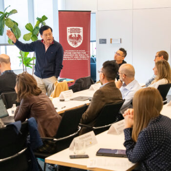 A seated audience of inequality scholars listens to a presenter during a Stone Center conference.