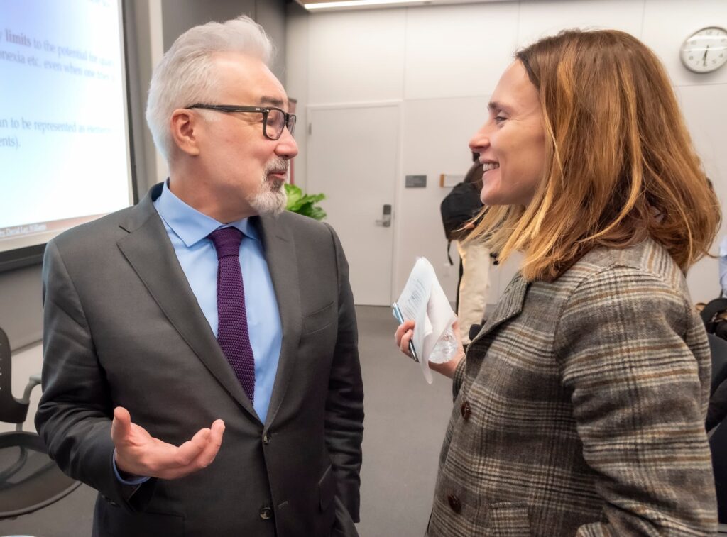 Two panelists engage in conversation following the session.