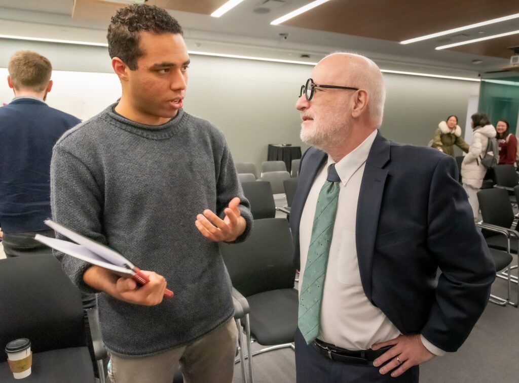 A panelist and audience member engage in conversation following the session.