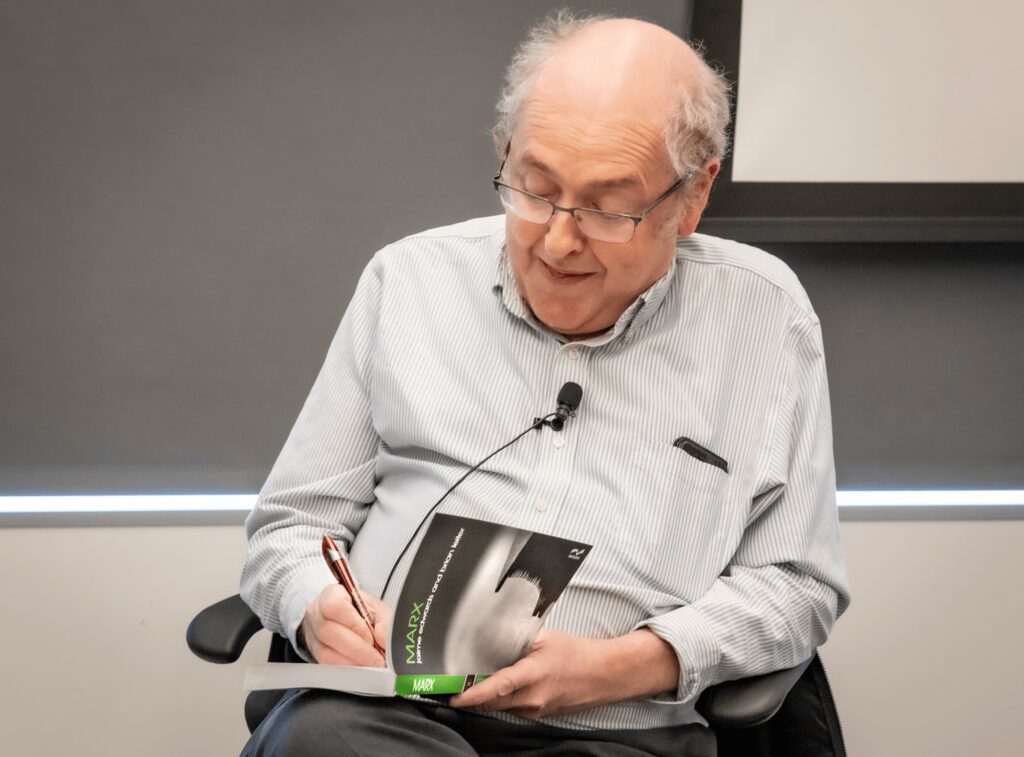 A panelist annotates a passage during the conversation.