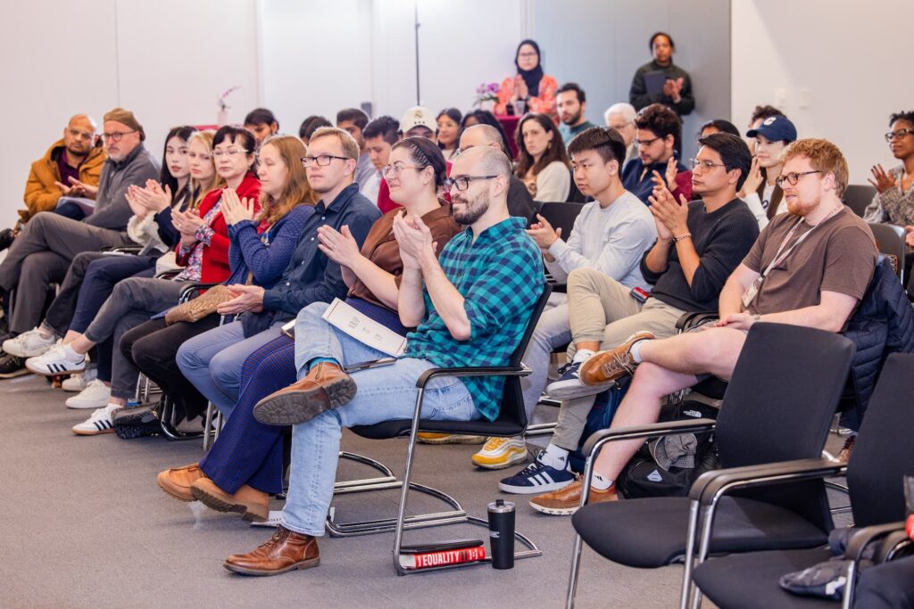 Audience members applaud at the close of the session.