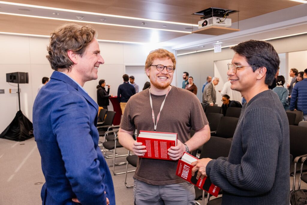 A panelist and two audience members engage in conversation following the session.