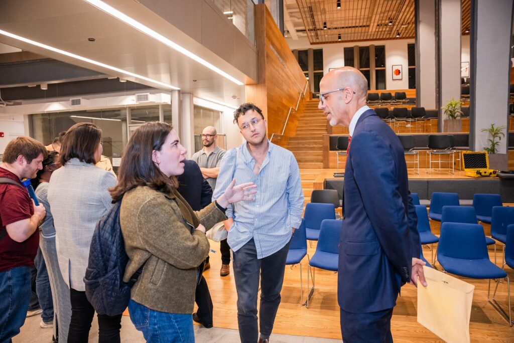 A panelist and audience member engage in conversation following the session.