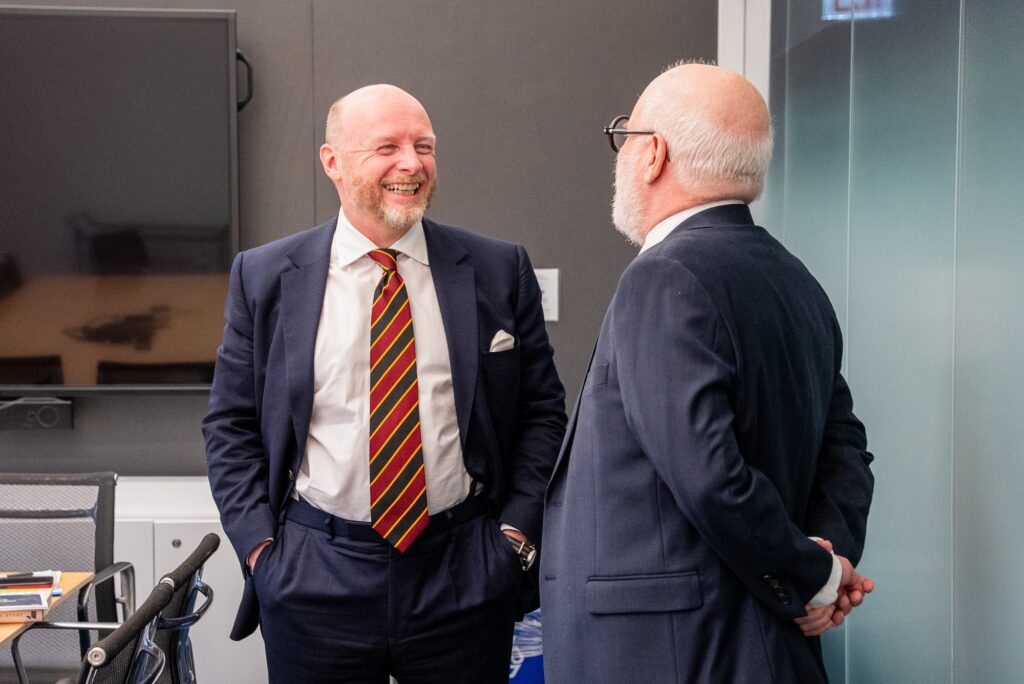 Two panelists share a light moment before the session.