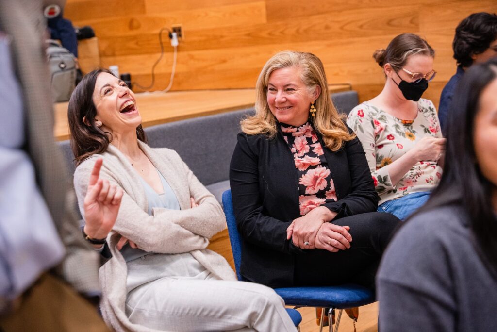 Two audience members share a light moment after the session.