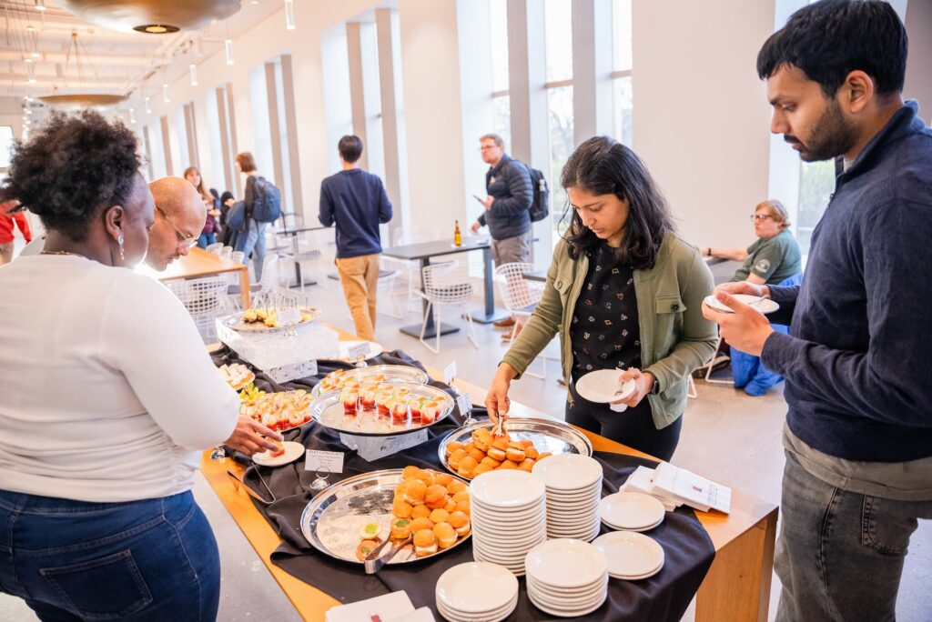 Attendees help themselves to refreshments after the discussion.