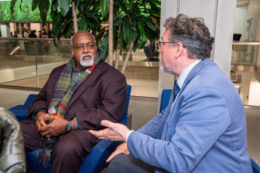 A panelist and an audience member engage in conversation following the session.