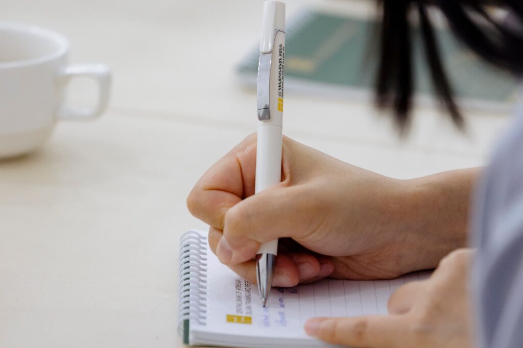 An attendee takes notes of the presentation.