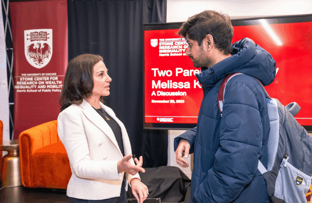 A panelist and an audience member engage in conversation following the session.