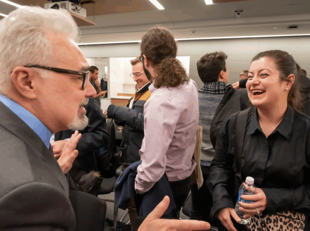 A panelist and a Stone Center member share a light moment after the session.